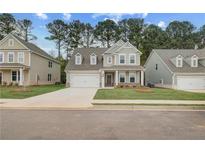 Inviting two-story home boasts a well-manicured lawn, attached garage, and charming craftsman-style details at 250 Arnewood Cir, Mcdonough, GA 30253