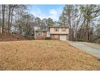 Charming two-story home featuring a brick facade, well-manicured lawn, and an attached garage at 620 Bell Se Rd, Conyers, GA 30094