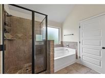 Beautiful bathroom featuring a glass enclosed shower with tile surround and soaking tub at 4249 Caveat Ct, Fairburn, GA 30213