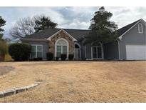 Charming one-story home featuring stone accents, neutral siding, and a well-manicured lawn at 1099 Wynford Cmns, Marietta, GA 30064