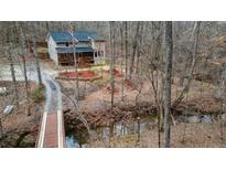 Charming home surrounded by mature trees and a quaint bridge leading to the property at 613 Rock Springs Pass, Dallas, GA 30157