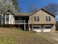 Charming home featuring a front-facing two car garage, quaint porch, and neutral siding at 1125 Durrell St, Austell, GA 30106