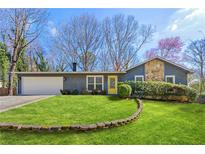 Charming home featuring a well-manicured lawn, stone accents, and a bright yellow front door at 4027 Cripple Creek Nw Dr, Kennesaw, GA 30144