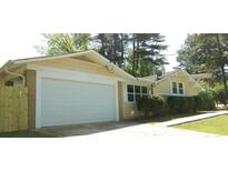 Charming single-story home features a two-car garage and a well-maintained front lawn at 688 Plainville Dr, Atlanta, GA 30331