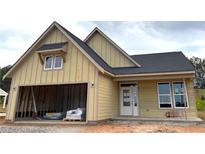 New construction with a yellow exterior, dark roof, and an attached garage, offering modern living at 33 Cambridge Ln, Dallas, GA 30157