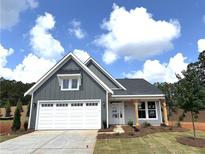 Charming single-story home with gray siding, white trim, a two-car garage, and a cozy front porch with wood supports at 33 Cambridge Ln, Dallas, GA 30157