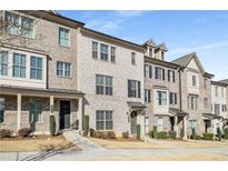 Charming townhome featuring a light brick facade, inviting porch, and neat landscaping at 4358 White Spruce Aly, Doraville, GA 30360