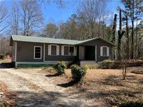 Charming single-story home with a metal roof and a partially wooded front yard at 8090 Colquitt St, Douglasville, GA 30134
