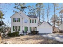 Charming two-story home with green shutters, a well-manicured lawn, and a two-car garage at 1056 Shadow Lake Dr, Lithonia, GA 30058