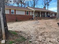 A ranch-style home with brick and vinyl siding, plus a covered porch and an expansive front yard at 5865 Leah Lane Ln, Powder Springs, GA 30127