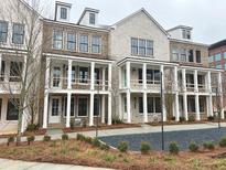 Charming townhomes showcasing white brick, large windows, and inviting covered entryways and lush landscaping at 2257 Addington Way # 56, Atlanta, GA 30319