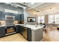 Modern kitchen featuring stainless steel appliances, dark cabinets, and a breakfast bar with seating at 32 Peachtree Nw St # 1105, Atlanta, GA 30303