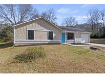 Inviting single-story home with a manicured lawn and a bright, eye-catching blue front door at 4912 Bayside Ct, Stone Mountain, GA 30088