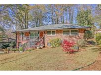 Charming brick home with a cozy screened porch and a lush front yard landscape, perfect for enjoying the outdoors at 2289 Montrose Dr, East Point, GA 30344