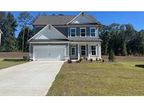Charming two-story home with gray siding, white trim, and a well-manicured lawn at 2554 Hickory Valley Dr, Snellville, GA 30078