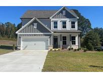 Charming two-story home featuring a gray and white color scheme, a two-car garage, and a well-manicured lawn at 2594 Hickory Valley Dr, Snellville, GA 30078