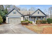 Charming single Gathering home with stone accents, well-maintained landscaping, and attached two-car garage at 1315 Thunder Gulch Pass, Suwanee, GA 30024