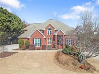 Beautiful brick two-story home with a well-manicured lawn and mature trees at 1574 Stepstone Way, Lawrenceville, GA 30043