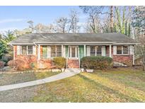 Charming single-story brick home featuring a well-maintained lawn and inviting front porch at 2330 Bonnybrook Way, East Point, GA 30344