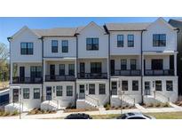 Charming townhome exterior featuring a white facade, black framed windows, and covered porches at 1408 Cozy Court # 303, Atlanta, GA 30315