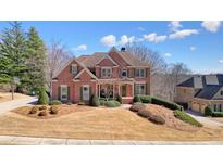 Beautiful two-story brick home with manicured lawn and mature landscaping at 586 Devon Brooke Dr, Woodstock, GA 30188