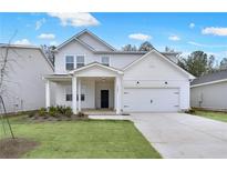 Charming two-story home featuring a welcoming front porch, a two-car garage, and a well-manicured lawn at 3204 Birdsong Ave, Covington, GA 30016