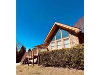 Charming home featuring a stone facade, large windows, and a wooden deck, blending natural materials with modern design at 3370 Stilesboro Nw Rd, Kennesaw, GA 30152