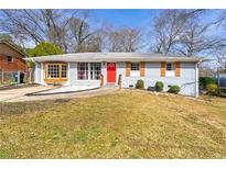 Charming single-story home with a red front door and a well-maintained front yard and beautiful bay window at 1082 Green Valley Nw Dr, Conyers, GA 30012