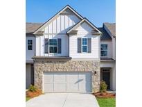 Charming townhome featuring a stone veneer, white siding, gray shutters and a two car garage at 2429 Bayberry St, Acworth, GA 30101