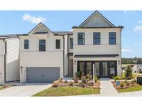 Charming two-story townhome with a painted brick facade, attached garage, and well-maintained landscaping at 982 Sutherland Ln (Lot 30), Lawrenceville, GA 30043