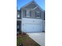 Charming two-story home with a spacious two-car garage and manicured landscaping at 7018 Old Bridge Ln, Conyers, GA 30013