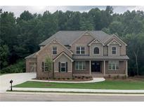 Charming brick home featuring a two-car garage, a well-manicured lawn, and meticulous landscaping at 4015 Sierra Vista Cir, Cumming, GA 30028