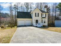 Charming two-story home featuring a spacious driveway, attached garage, and a cozy front porch entrance at 581 Victorian Cir, Dallas, GA 30157