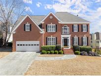 Charming brick two-story home with a well-manicured lawn and a two-car garage at 602 Kenion Forest Way, Lilburn, GA 30047