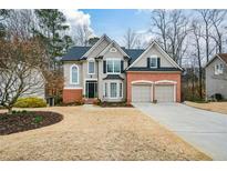 Charming two-story home with a well-manicured front yard and attached two-car garage at 608 Ridge Crossing Dr, Woodstock, GA 30189