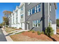 Modern townhome exterior featuring a gray brick facade and manicured landscaping at 310 Mcdonough Se Blvd # 101, Atlanta, GA 30315