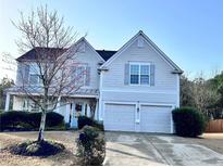 Charming two-story home with a well-manicured lawn and a two-car garage at 690 Floral Pl, Suwanee, GA 30024