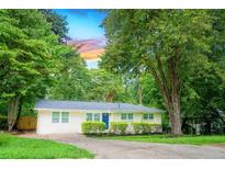 Charming single-story home with a well-manicured lawn and mature trees, offering great curb appeal at 1975 Glenmar Dr, Decatur, GA 30032