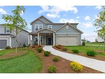 Charming two-story home with a welcoming front porch, landscaped yard and a two-car garage at 3071 Birdsong Ave, Covington, GA 30016