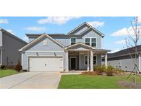 Charming two-story home with a covered front porch, a two-car garage, and a well-manicured lawn at 3071 Birdsong Ave, Covington, GA 30016