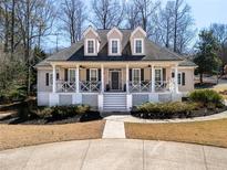Charming two-story home featuring a covered front porch, dormer windows, and manicured landscaping at 3345 Highgate Hills Ne Dr, Duluth, GA 30097