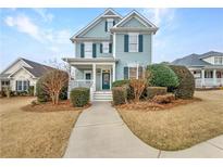 Charming two-story home with light blue siding and a welcoming front porch at 185 Stayman Park, Fayetteville, GA 30215