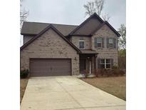 Charming two-story brick home featuring an attached two-car garage and manicured front lawn at 4954 Zoya Sw Ct, Atlanta, GA 30331