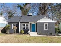 Charming single-story home with a gray brick exterior, bright blue front door, and well-maintained landscaping at 1802 S Gordon Sw St, Atlanta, GA 30310