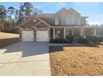 Charming two-story brick home featuring a two-car garage and inviting front porch at 1350 English Manor Cir, Stone Mountain, GA 30087
