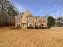 Traditional two-story brick home featuring manicured landscaping and a symmetrical facade at 175 Stillwood Dr, Fayetteville, GA 30215