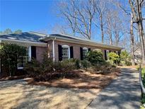 Charming brick home with black shutters and a well-maintained lawn and walkway at 295 Weatherstone Ln, Marietta, GA 30068