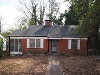Charming red brick home featuring a classic design with a small chimney and a lovely screened-in front porch at 1191 Beechview Se Dr, Atlanta, GA 30316