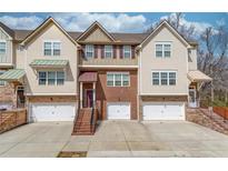 Charming townhome showcasing neutral siding, brick accents, and inviting garage entrances, blending comfort with classic design at 4288 Buford Valley Way, Buford, GA 30518