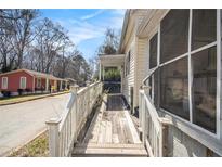Side view of a yellow one story house featuring a wooden ramp and screened-in porch at 207 Taylor Cir, Palmetto, GA 30268